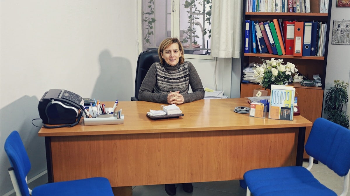 woman sitting beside desk near bookcase with books